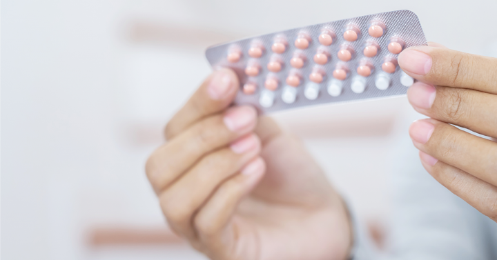 Hand holding an array of pills in a tray