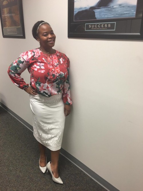 Woman posing next to a poster that defines success