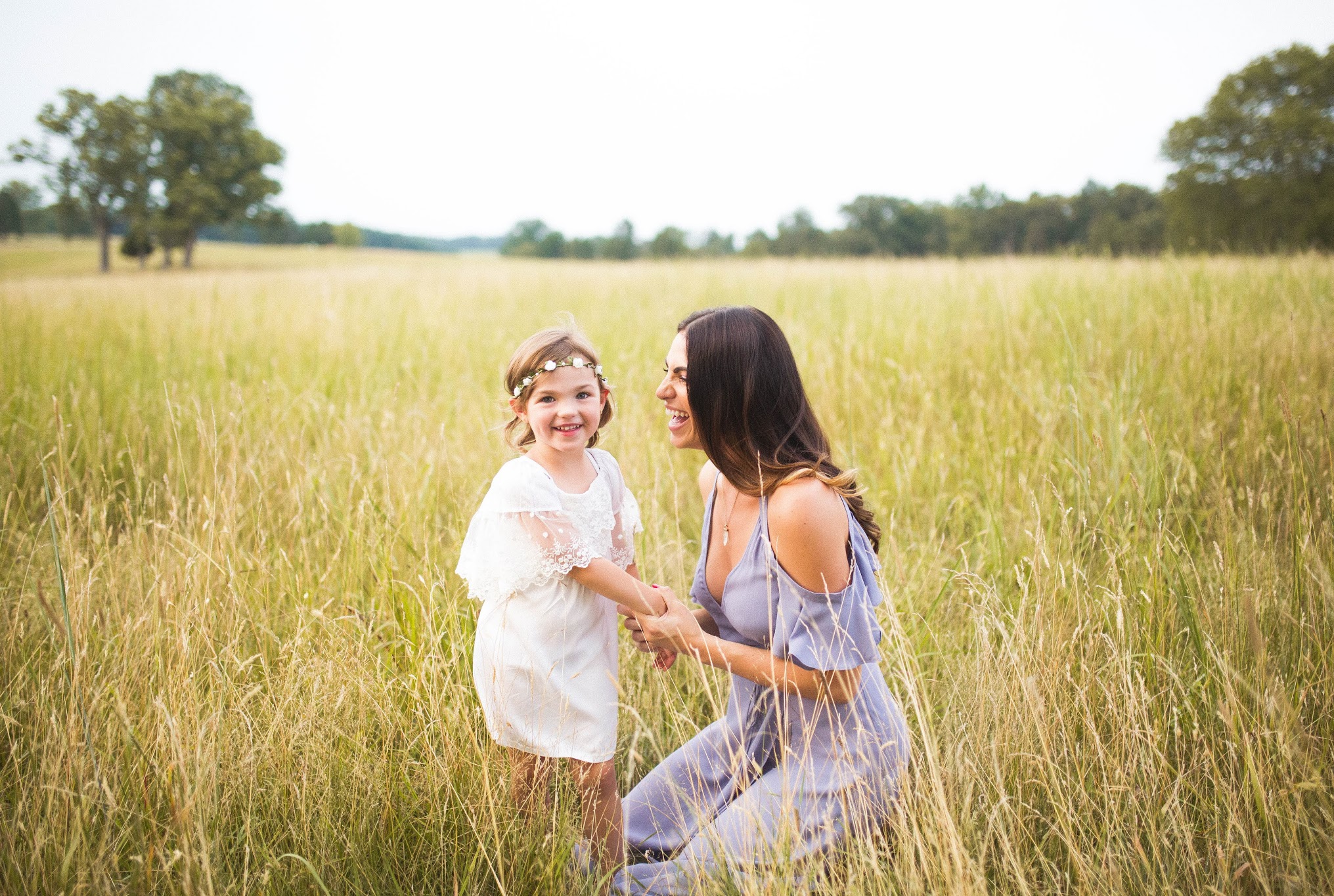 A child playing with their mother in a field