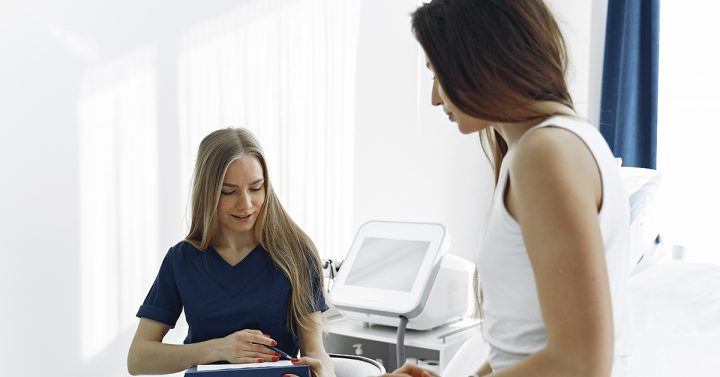 Woman talking with her doctor as the doctor takes notes