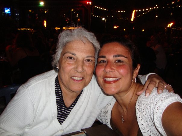 Two women posing together in a dimly lit place