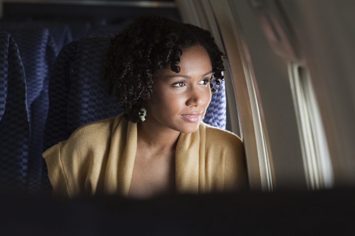 Lady peering out the window of a plane