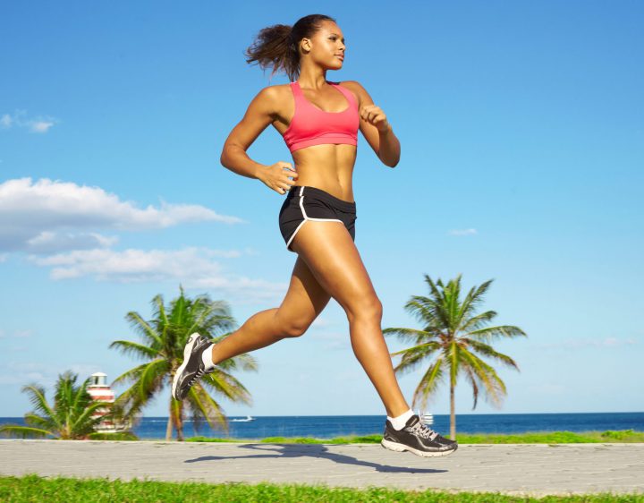 A woman running on a path near open water