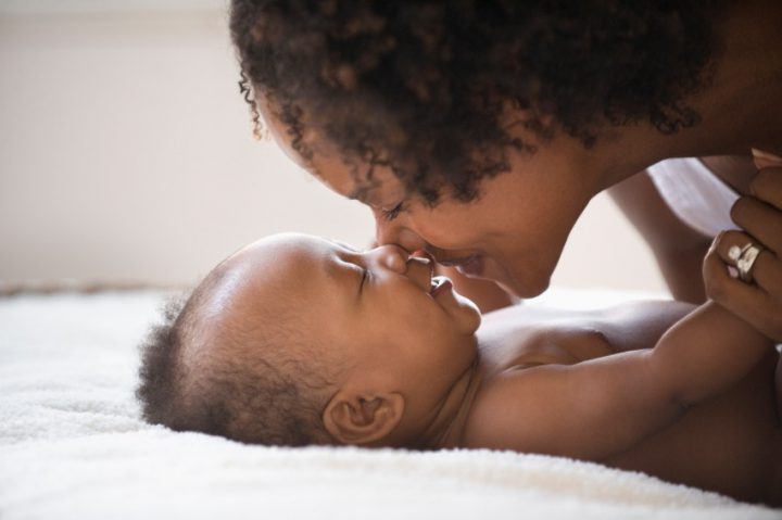 A mother touches her nose the her baby's nose