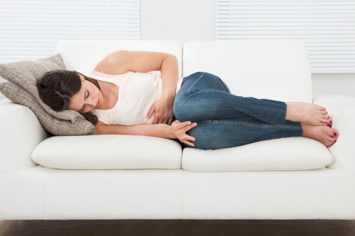 Lady in a white shirt laying on her couch